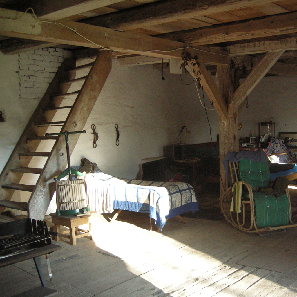 Wnętrze młyna i widok na zachowane "schody" na pierwsze piętro. Słup za fotelem, jak i większość belek zostały zachowane